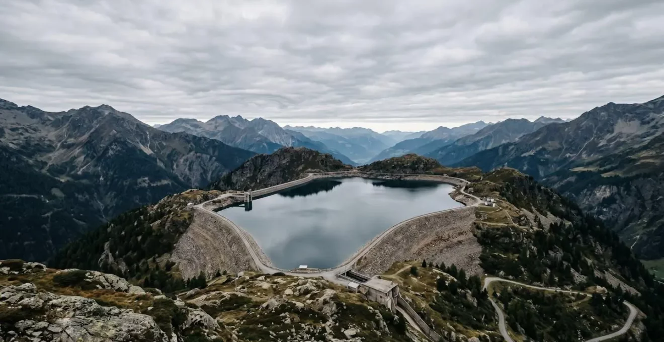 Vue environnementale minimaliste d'un réservoir hydraulique dans un paysage montagneux avec espace négatif